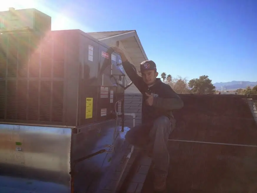 HVAC technician performing AC Tune-Up on a rooftop unit in Middleburg
